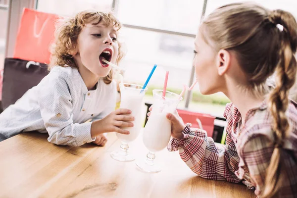 Children drinking milkshakes with straws — Stock Photo, Image