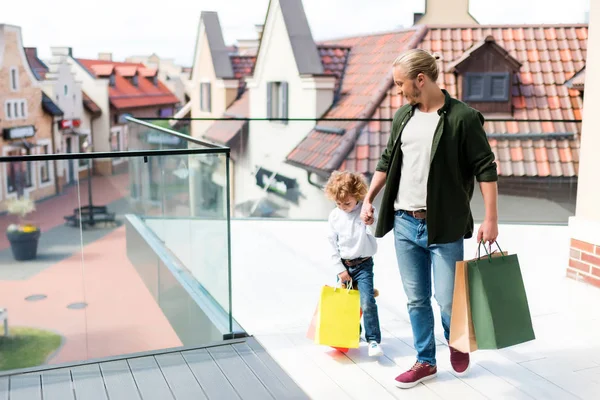 Far och son håller kassar och påsar — Stockfoto