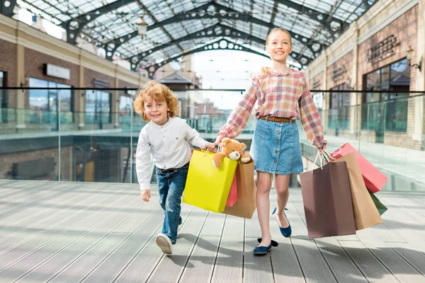 Χαρούμενα παιδιά, κρατώντας τσάντες για ψώνια — Φωτογραφία Αρχείου