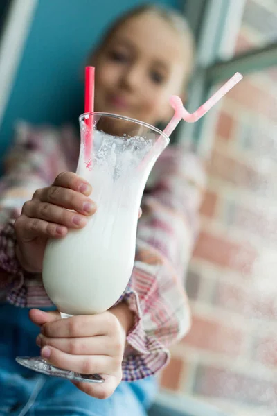 Girl holding glass of milkshake — Stock Photo, Image