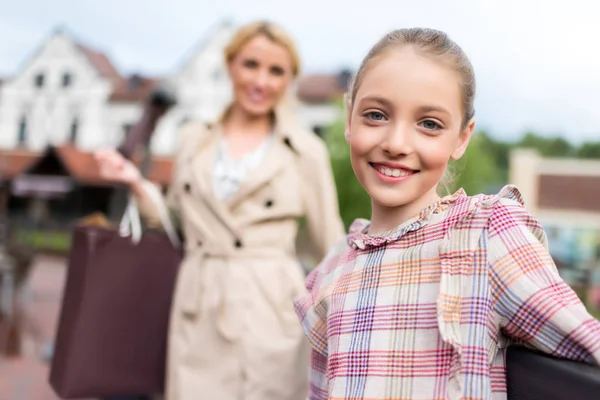 Chica con madre con bolsas de compras —  Fotos de Stock