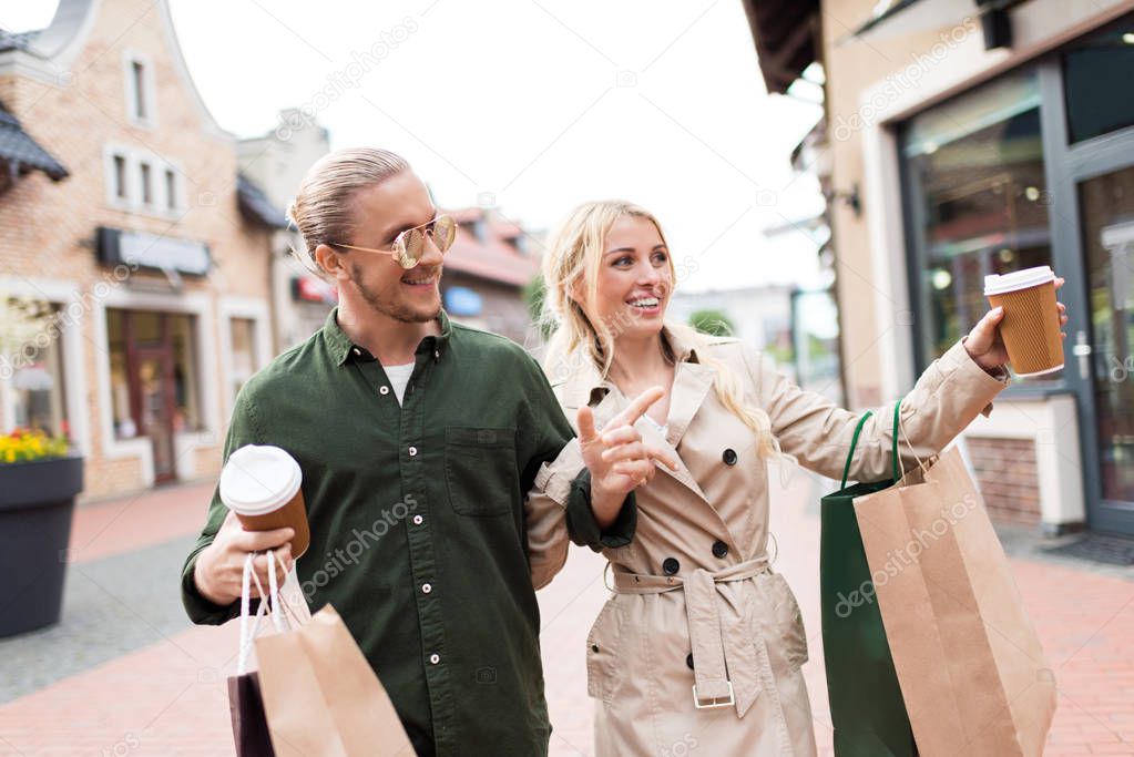 couple walking with shopping bags on street 