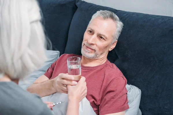 Woman giving water to husband — Stock Photo, Image