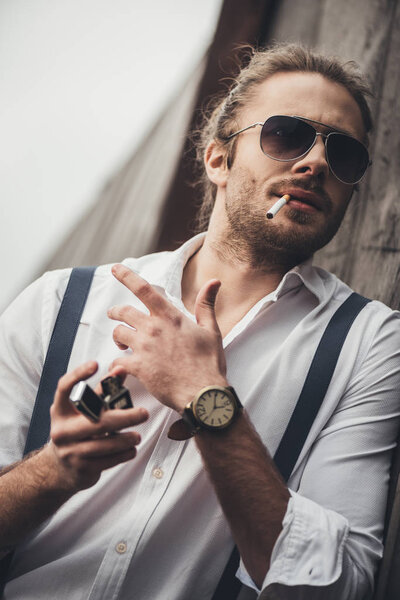 Стильный молодой человек курит
