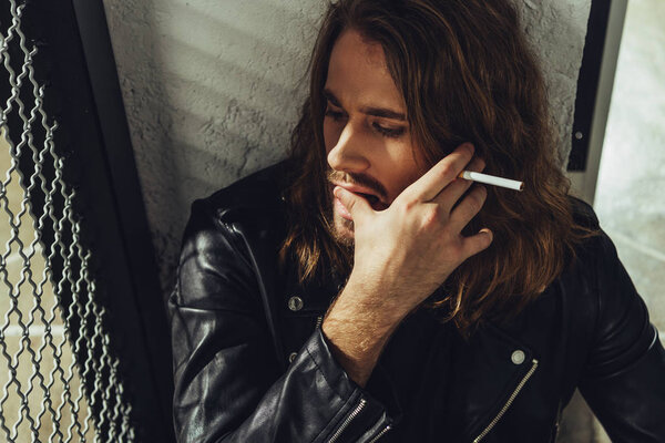 Stylish long haired man with cigarette