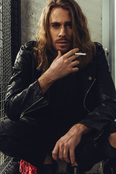 Stylish long haired man with cigarette