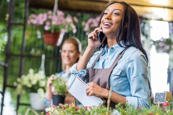 Fiorista parlando su smartphone — Foto Stock