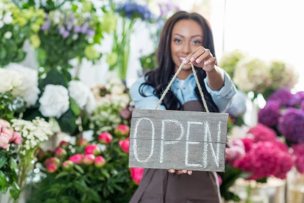 Floristería sosteniendo signo abierto — Foto de Stock