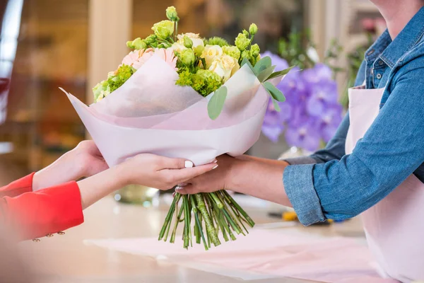 Blumenhändler überreicht Blumenstrauß an Kundin — Stockfoto