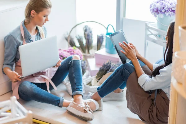 Floristas multiétnicos utilizando gadgets — Foto de Stock