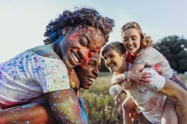 multiethnic friends at holi festival clipart