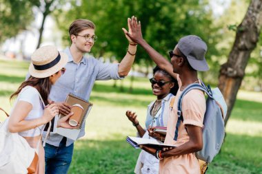 Çak bir beşlik vererek çok ırklı öğrenciler