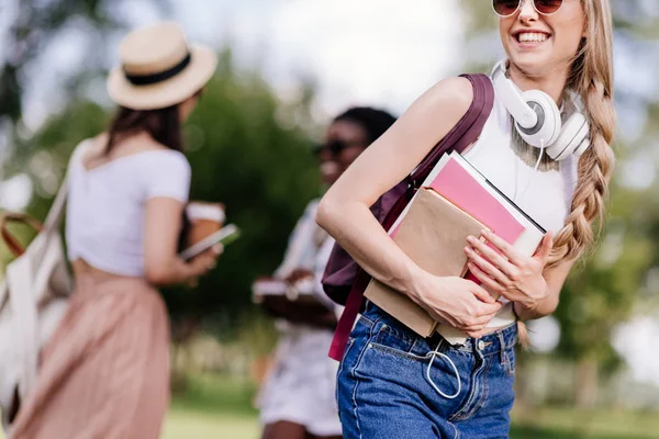 Lächelndes Mädchen mit Büchern im Park — Stockfoto