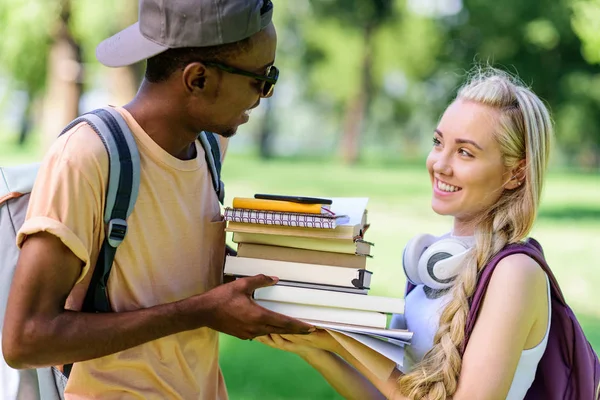 Pareja multiétnica con libros en el parque — Foto de Stock