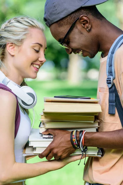 Pasangan multietnis dengan buku-buku di taman — Stok Foto