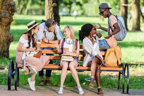 Multiethnic students on bench in park — Stock Photo, Image