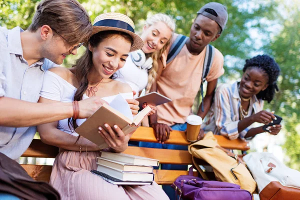 Estudantes multiétnicos no banco no parque — Fotografia de Stock