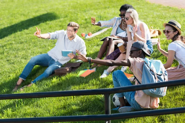 Estudantes multiétnicos descansando no parque — Fotografia de Stock