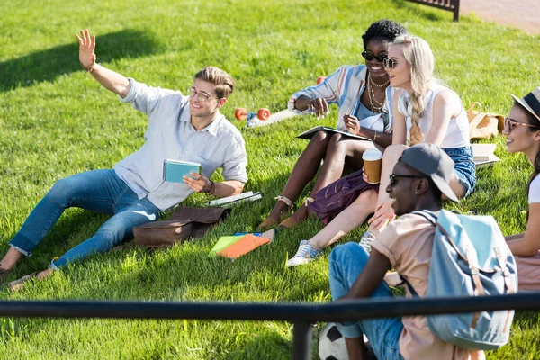 Estudantes multiétnicos descansando no parque — Fotos gratuitas