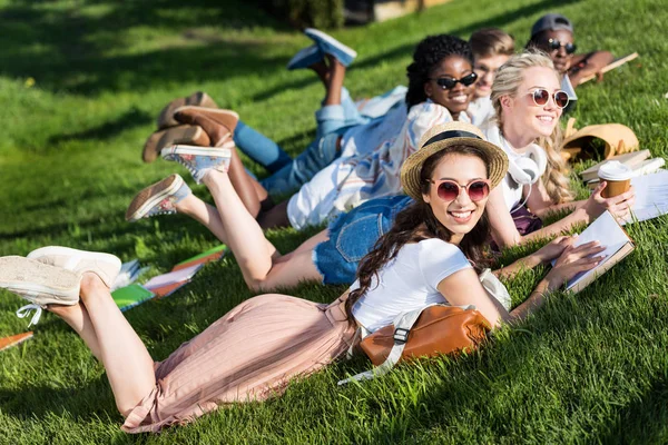 Estudantes multiétnicos lendo livros no parque — Fotografia de Stock