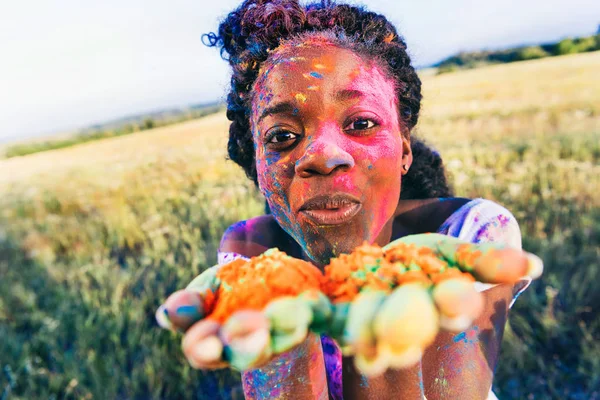 Mujer soplando polvo colorido — Foto de Stock