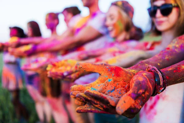 Colorful powder in hands — Stock Photo, Image