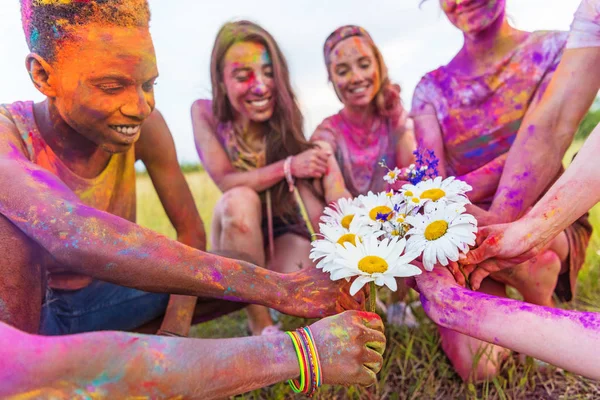 Amigos segurando camomilas — Fotografia de Stock