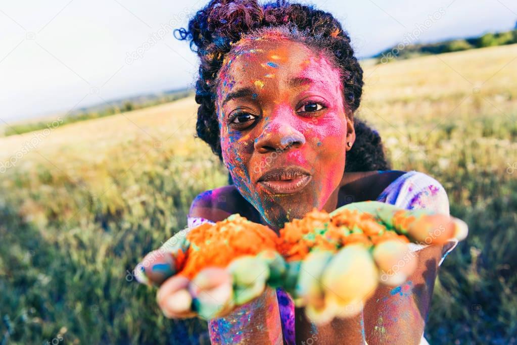 woman blowing colorful powder