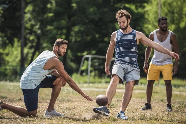 Мультикультурні чоловіки грають у футбол — стокове фото