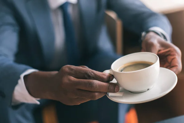 Empresário segurando xícara de café — Fotografia de Stock