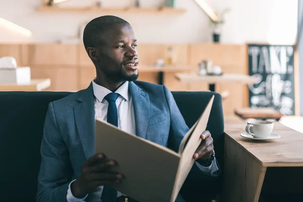 Hombre de negocios menú de lectura en la cafetería — Foto de Stock