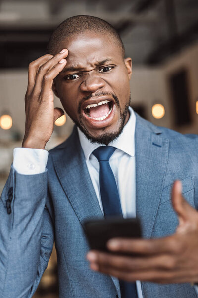 Злой бизнесмен, использующий смартфон
