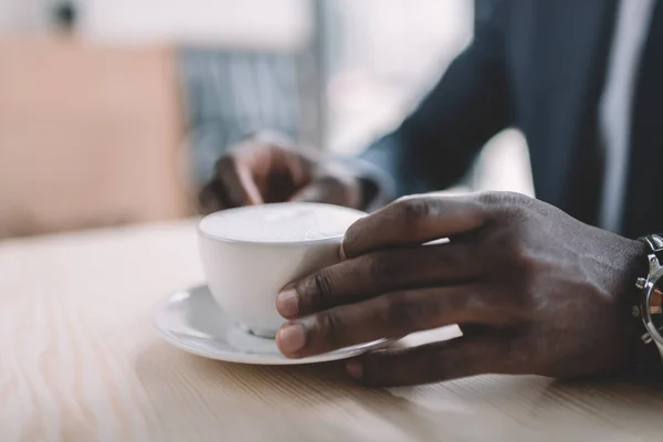 Affärsman anläggning kaffe kopp — Stockfoto