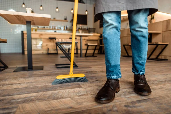 Man brooming in coffee shop — Stock Photo, Image