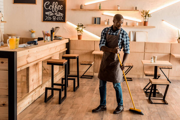 man brooming in coffee shop