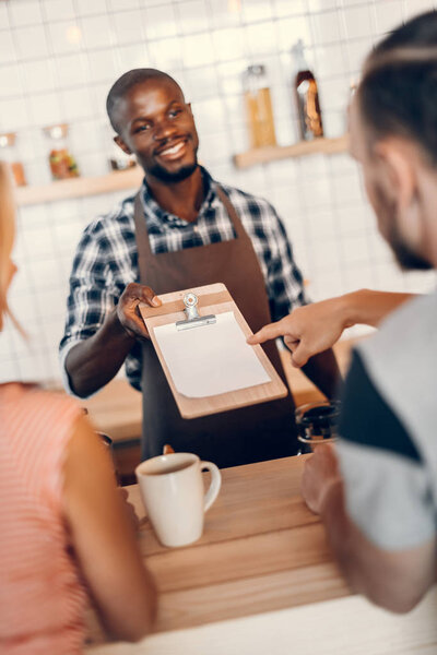barista giving menu to clients 