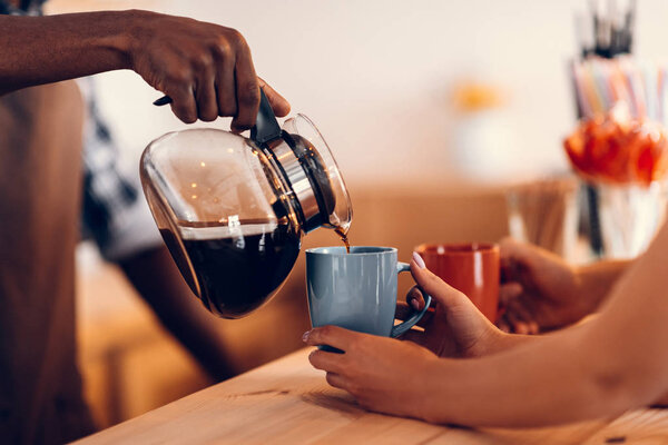 barista pouring coffee on bar