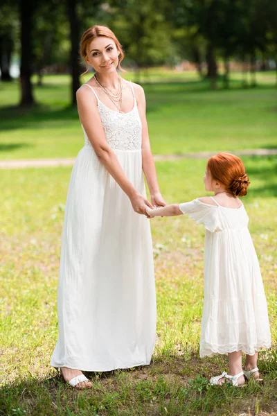Мать и дочь держатся за руки в парке — стоковое фото