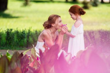 mother and daughter near flower bed clipart