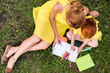 mother and daughter drawing in park clipart