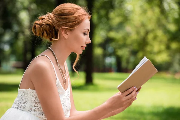 Young woman with book at park — Stock Photo, Image