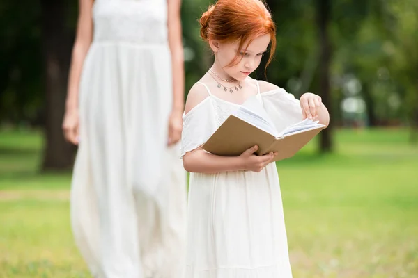 Mädchen liest Buch im Park — Stockfoto