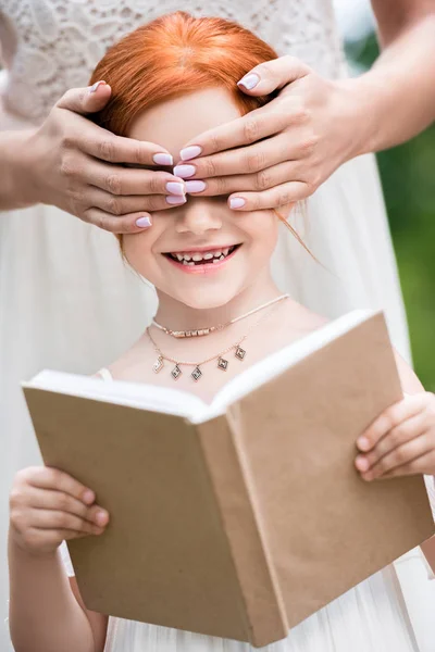 Moeder en dochter met boek bij park — Gratis stockfoto