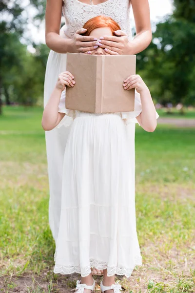 Moeder en dochter met boek bij park — Gratis stockfoto