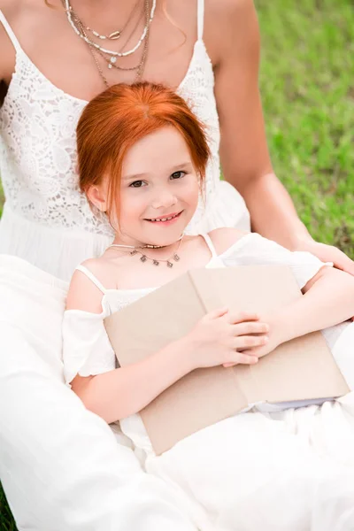 Mãe e filha com livro no parque — Fotografia de Stock