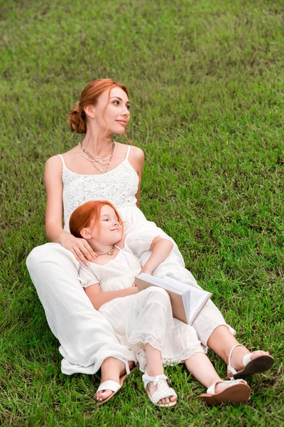 Mãe e filha com livro no parque — Fotografia de Stock