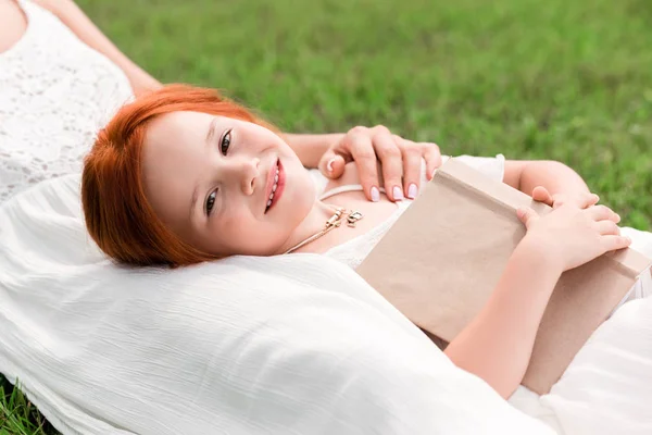 Mother and daughter with book at park — Stock Photo, Image