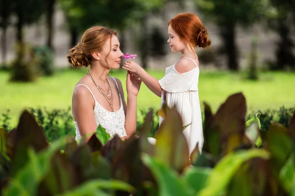 Madre e hija cerca del macizo de flores — Foto de Stock