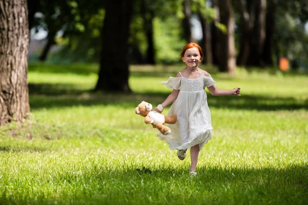 Meisje met teddybeer in park — Stockfoto