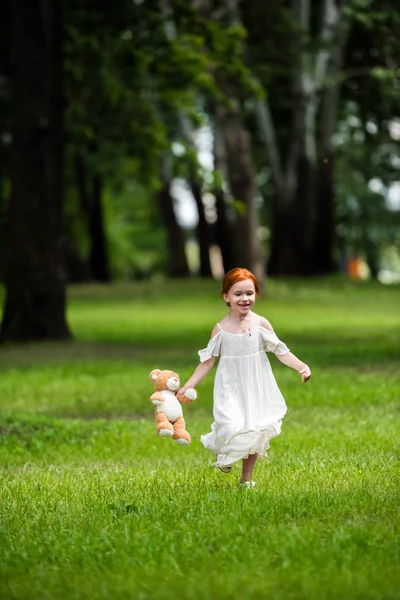 Girl with teddy bear in park — Stock Photo, Image